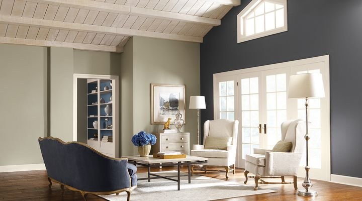 Living room with sage green walls, a charcoal accent wall and a whitewashed wood ceiling