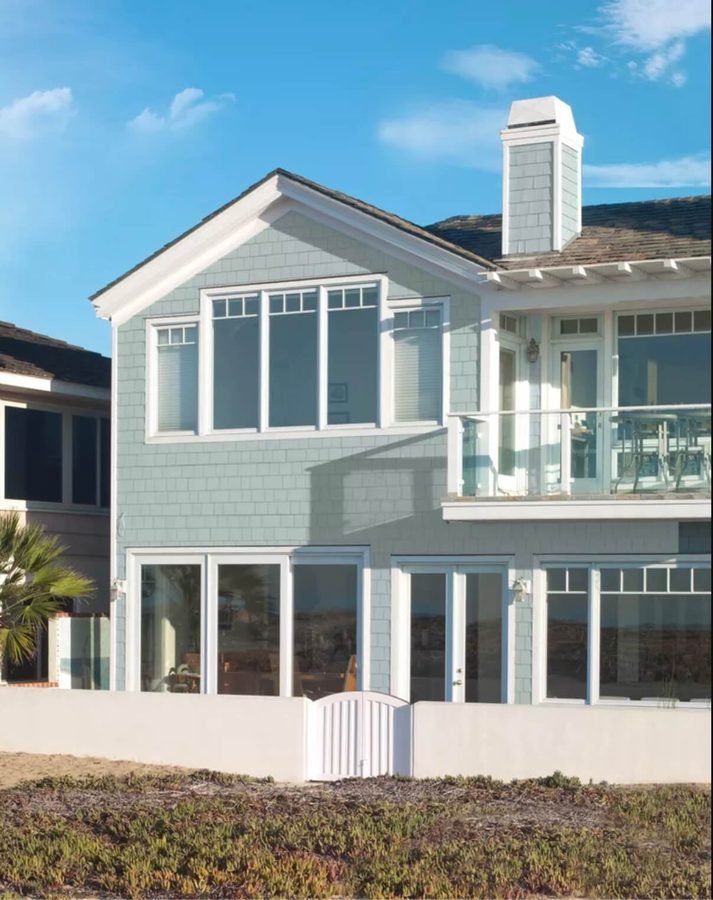 Pale blue-gray shingled house with crisp white trim
